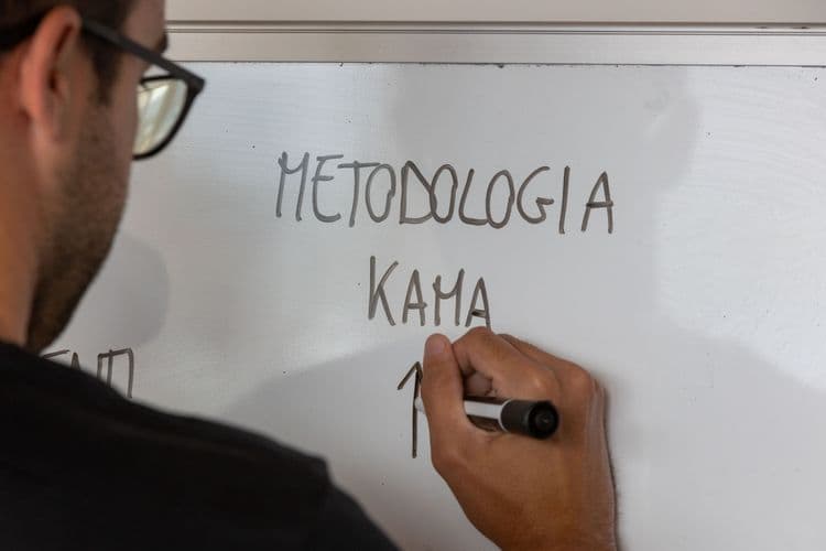 Person writing on white board about Kama.Sport